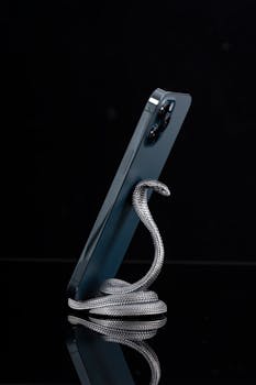 Elegant snake-shaped phone stand made of oxidized silver, adding a unique touch to your desk decor.