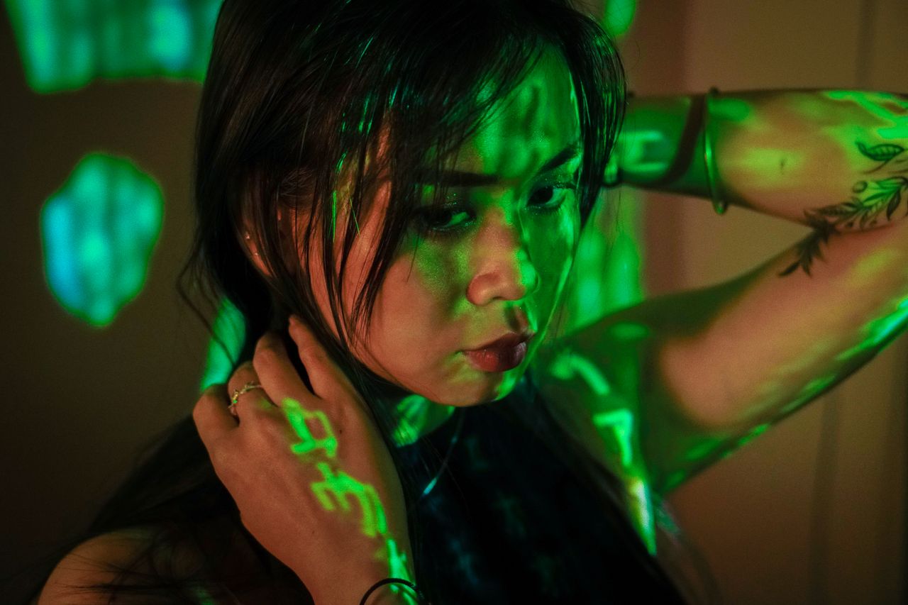 artistic portrait of a woman with green light and shadow effects