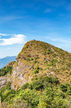 A lush green mountain peak under a vibrant blue sky, perfect for nature enthusiasts.