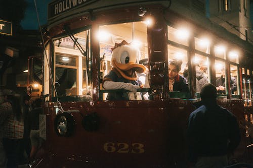 People in Vintage Tram with Person in Duck Costume at Night