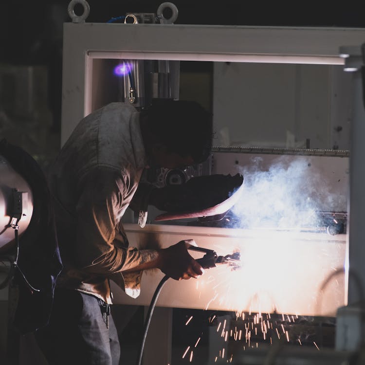 Man Welds the Casing of the Machine