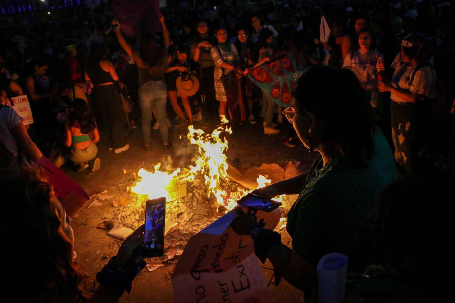 Activists gather around a bonfire during a night rally in Mexico City.