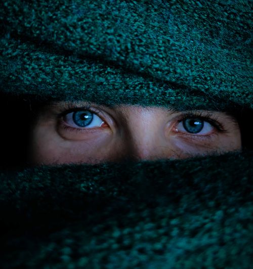 Free Mysterious eyes peeking through a green scarf, capturing a sense of intrigue and curiosity. Stock Photo