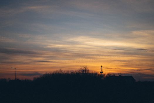 Silhouetted Trees, Lanterns an Roofs of Houses at Sunset