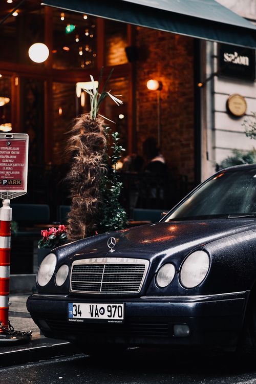 Free Elegant Mercedes-Benz parked on a rainy urban street at night. Stock Photo