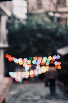 Blurred background of an urban alley with vibrant bokeh lights creating a dreamy atmosphere.