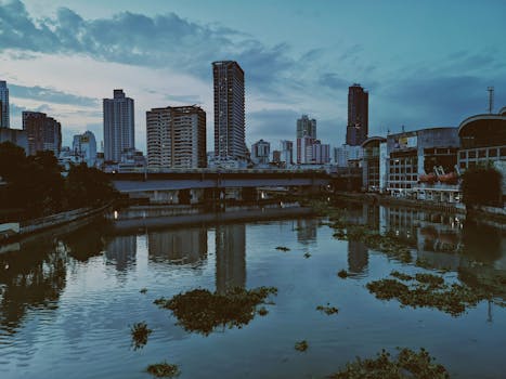 黄昏时分，城市滨水天际线的如画景色倒映在河中，展现了城市建筑的魅力