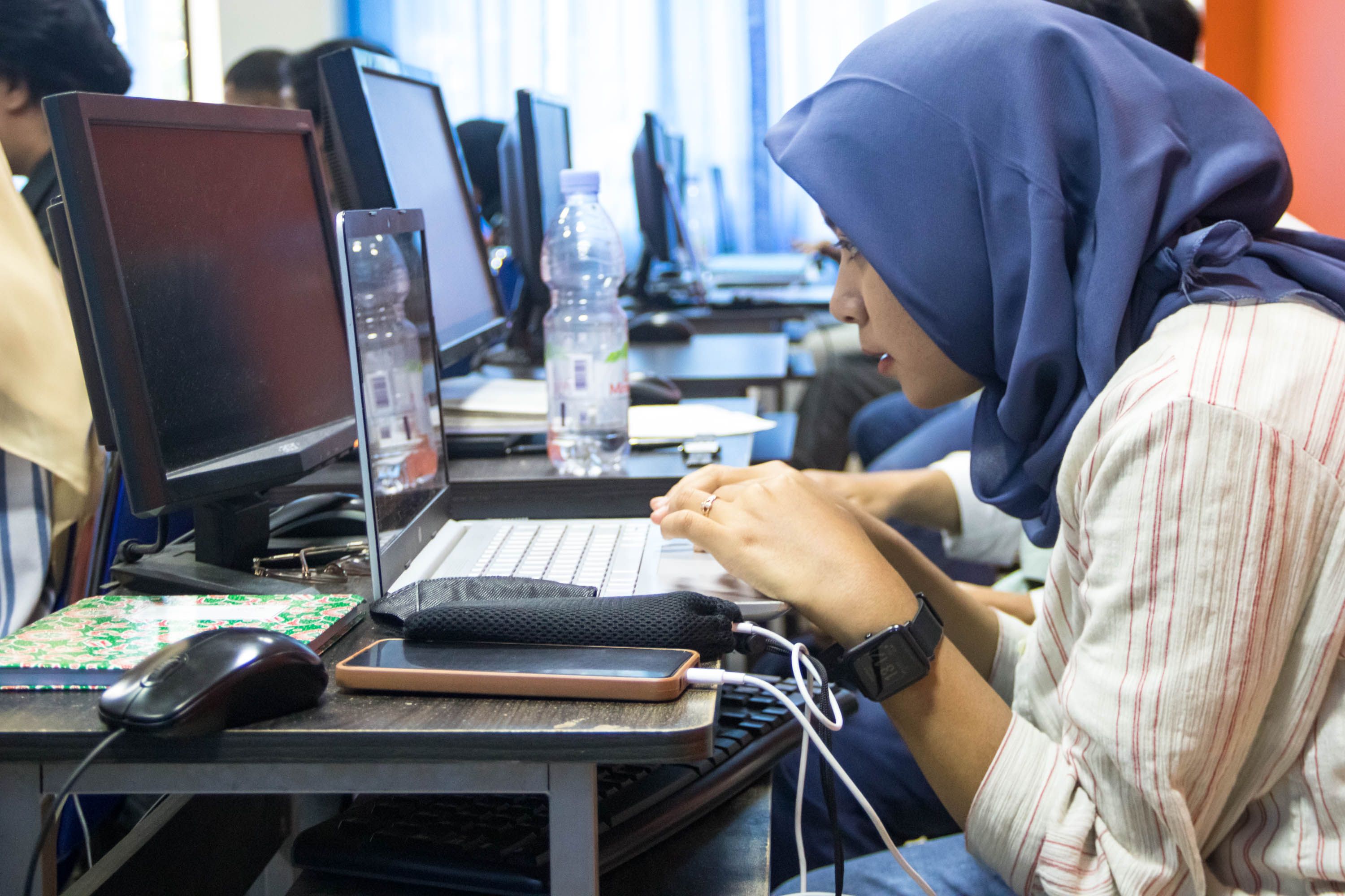A woman learning in a computer classroom