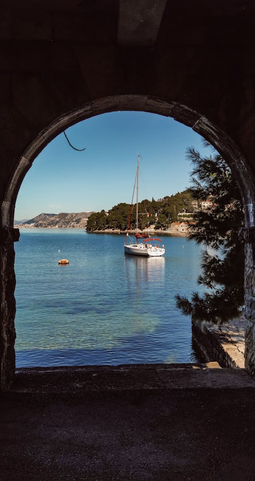 Sailboat behind Arch on Shore