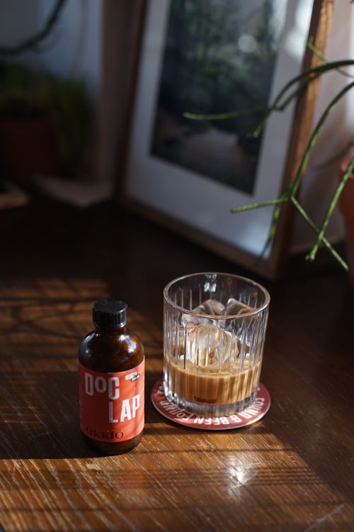 Free Warm indoor setting featuring an iced coffee and bottle on a wooden surface. Stock Photo