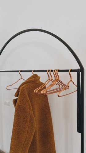 Camel teddy coat on a minimal rack — photo by Margarita on Pexels