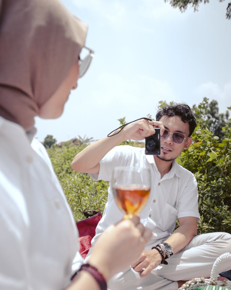 Man Taking Photo Of Woman Holding Wine