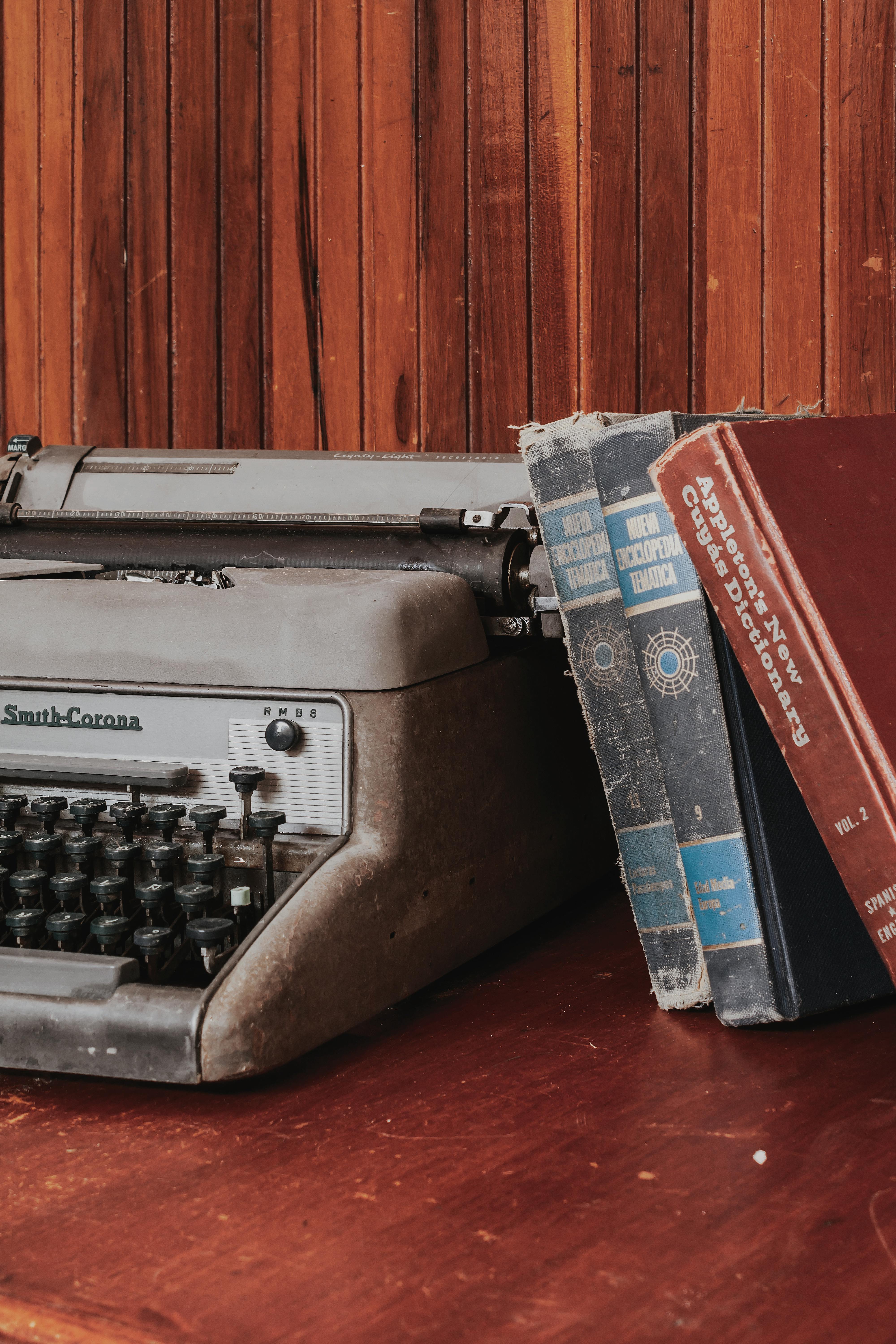 an old typewriter sits on top of a wooden table