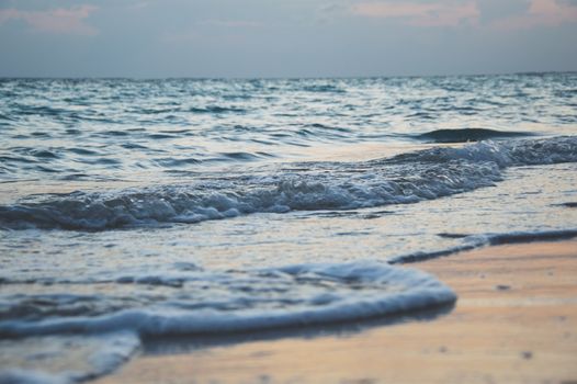 Peaceful beach waves rolling gently at sunset with a serene sea view.