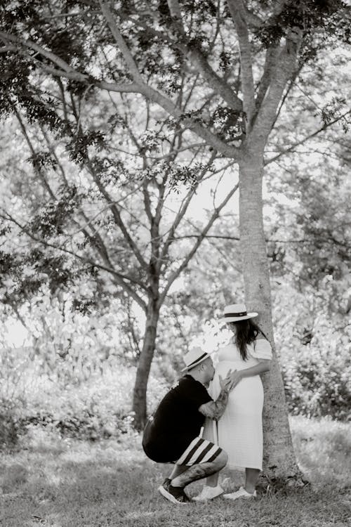 Pregnant Woman and Man Together under Tree