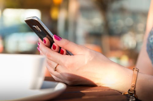 Persoon Met Een Zwarte Smartphone Met Een Horloge Met Een Bruine Lederen Band