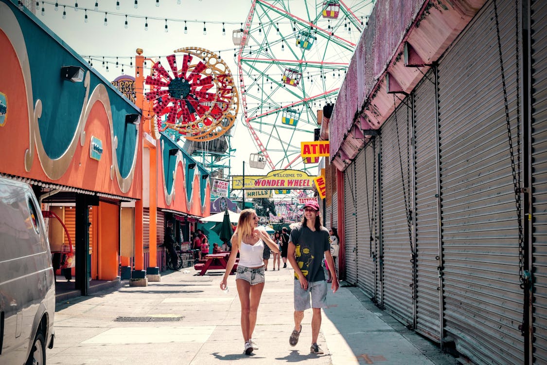 Free Woman and Man Walking in the Carnival during Daytime Stock Photo
