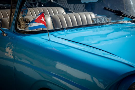 Classic blue convertible with Cuban flag in Varadero, capturing retro charm.
