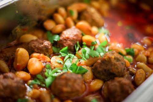 Free Close-up of a mouth-watering bean and meatball stew garnished with fresh herbs. Stock Photo