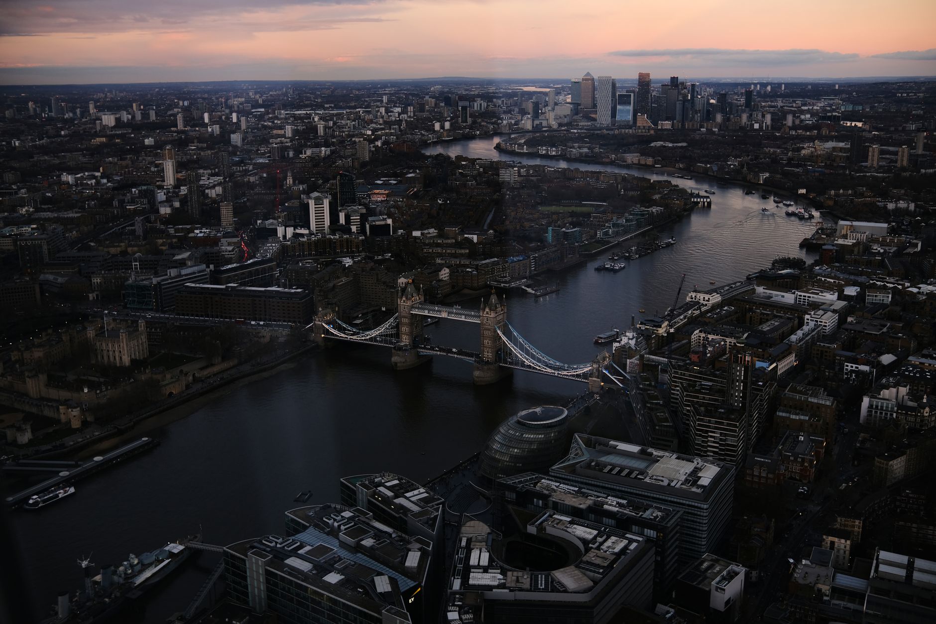 Stunning aerial view of London featuring Tower Bridge and Thames River during sunset.