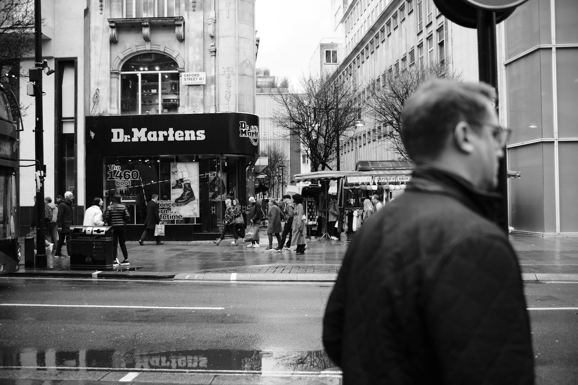 Monochrome view of bustling Oxford Street in London featuring pedestrians and a Dr. Martens store.