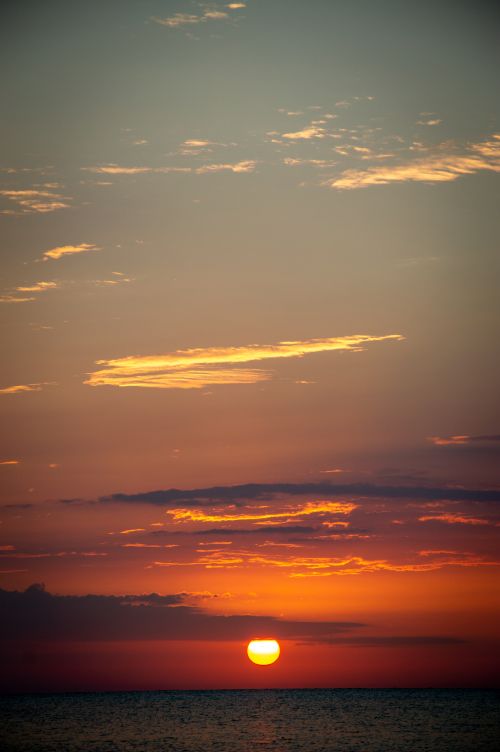 Free Beautiful sunset over the ocean with dramatic sky and vibrant colors, perfect for nature lovers. Stock Photo