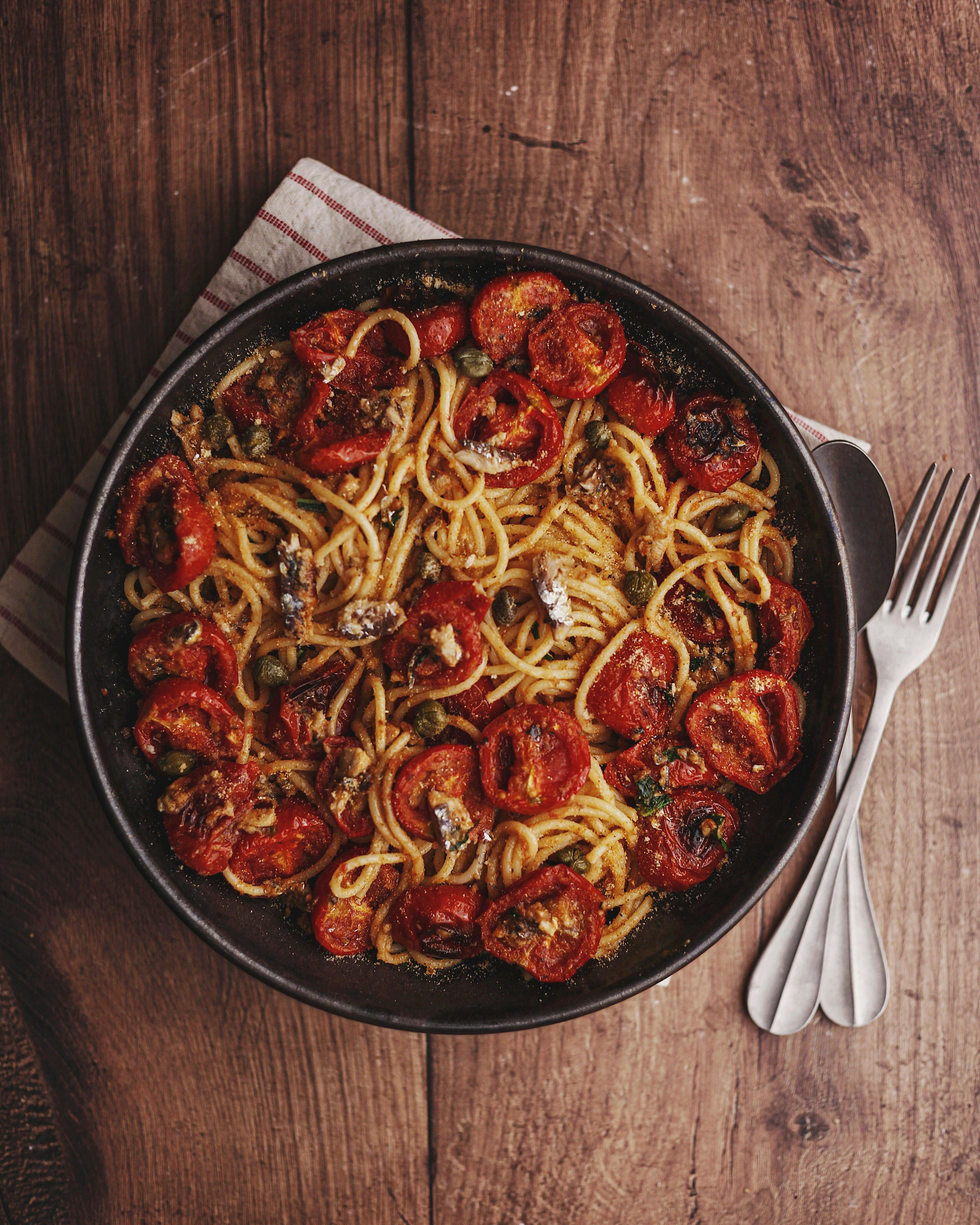 Top view of spaghetti with roasted tomatoes and parmesan. Perfect for Italian cuisine lovers.