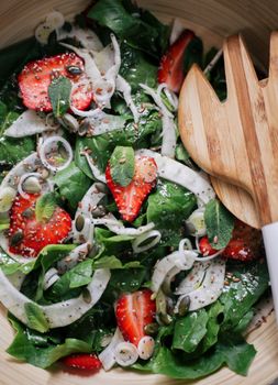 Appetizing spinach and strawberry salad including fennel and seeds, perfect for a healthy meal.