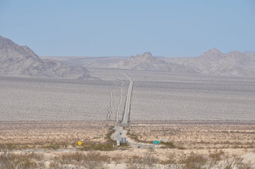 Highway across a Barren Landscape with Mountains in the Distance 