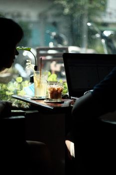 Casual coffee shop setting with drinks and laptop on a table, perfect for remote work vibes.