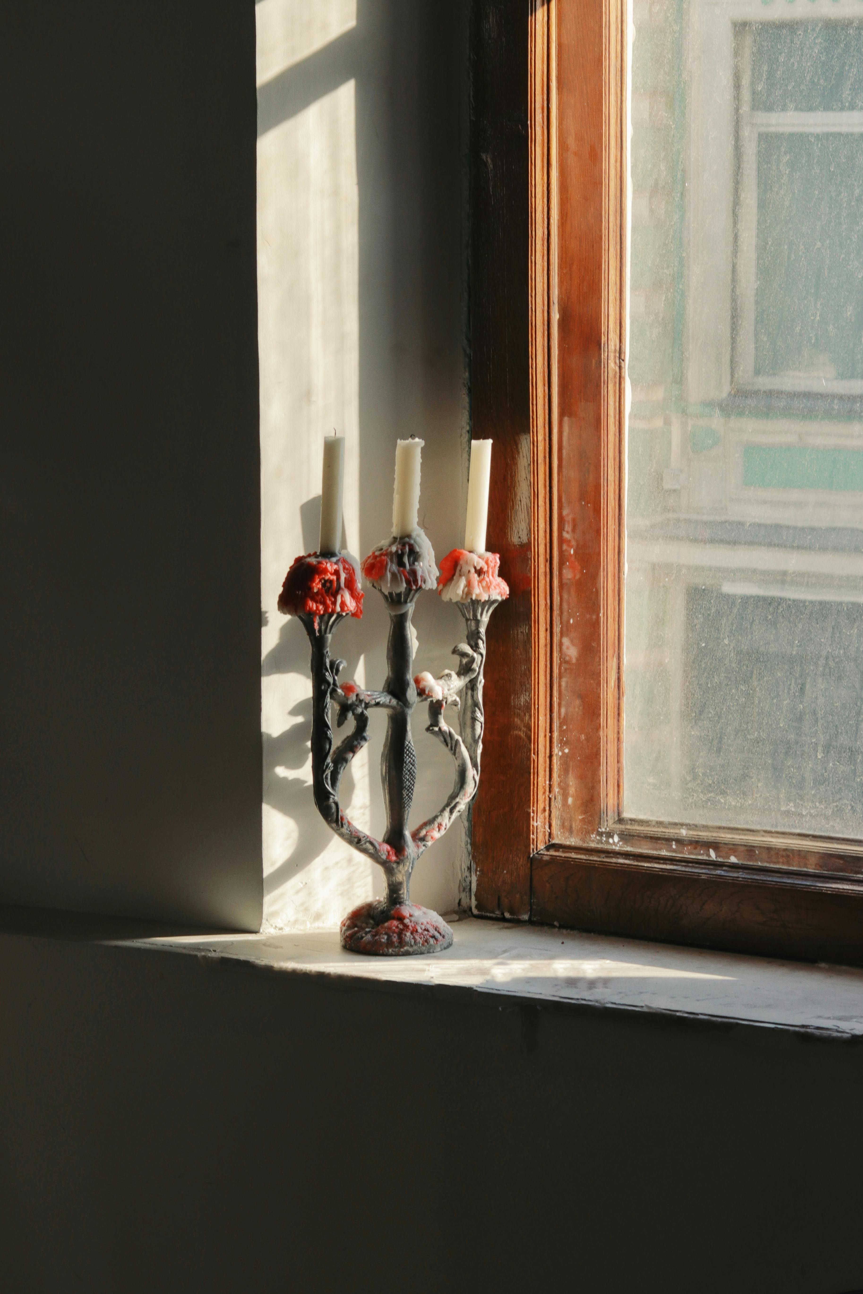 Candlesticks in a Vintage Candle Holder on a Windowsill · Free Stock Photo