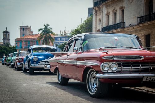 Free Classic American cars parked on a vibrant street in Havana, Cuba. Stock Photo
