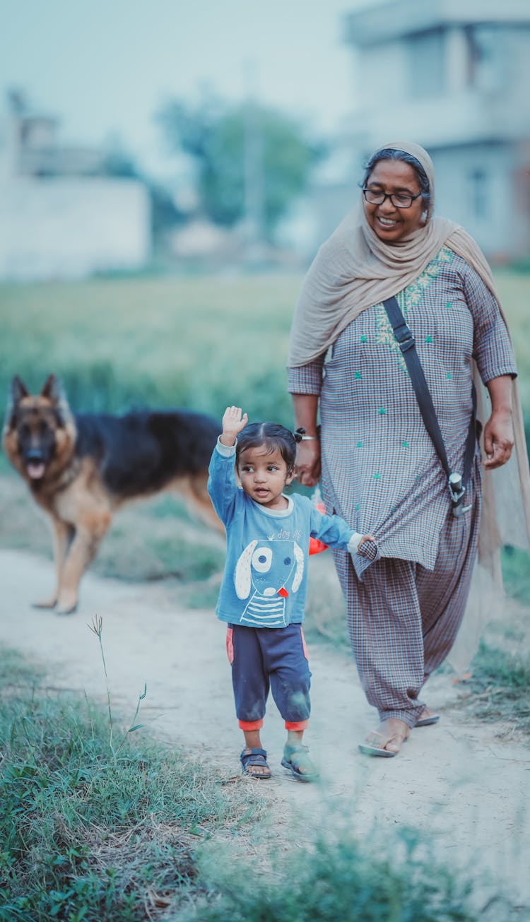 Photo Of A Woman Walking With A Child