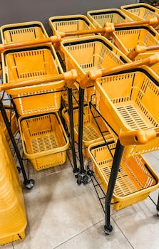 Several yellow shopping carts stacked neatly indoors, perfect for retail and shopping concepts.