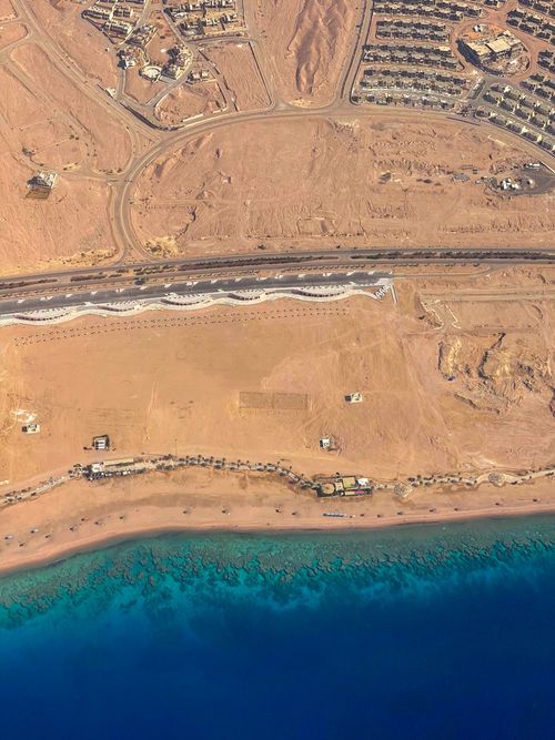 Free A stunning aerial view of Aqaba's desert meeting the Red Sea, showcasing contrasts and natural beauty. Stock Photo