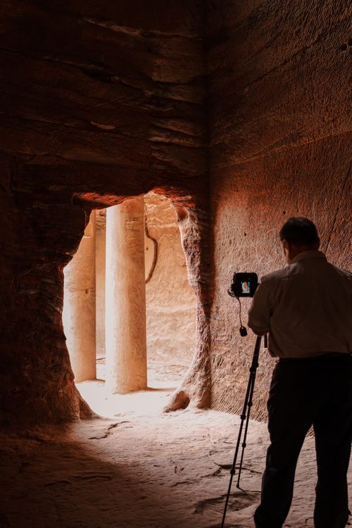 Free Photographer in Petra, Jordan, captures the ancient rock-carved architecture with a camera. Stock Photo