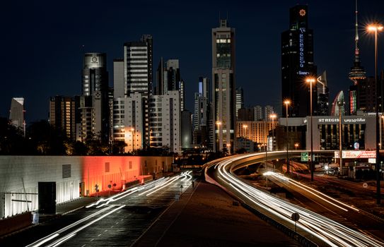 Illuminated night view of Kuwait City skyline showcasing modern architecture.