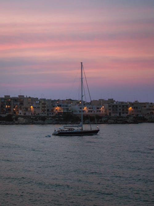 Immagine gratuita di barca a vela, cielo rosa, città