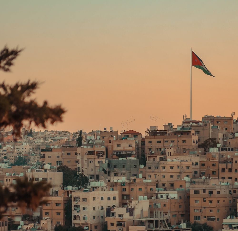 Bandera de Jordania sobre Amán al atardecer