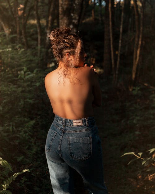 Topless Woman in Blue Jeans Posing in a Forest 