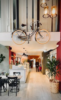 Modern cafe interior featuring a bicycle decor on the wall with warm lighting and indoor plants.