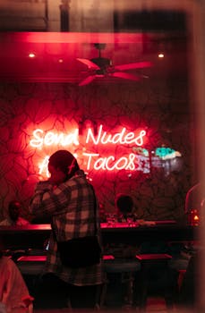 Vibrant nightlife atmosphere with a neon sign in a bar setting, capturing the essence of urban evenings.