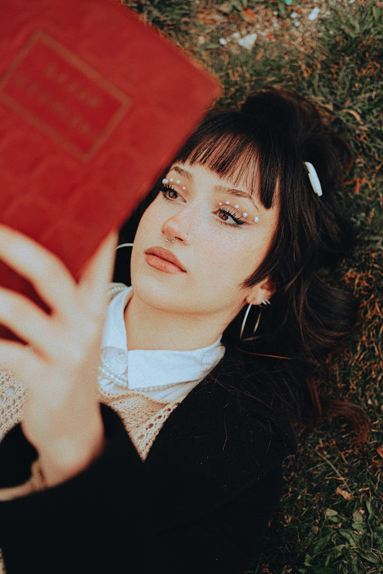 Portrait Of Woman Lying On Grass And Reading