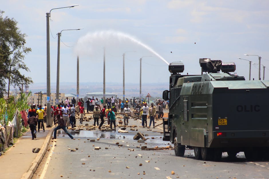 A tense protest scene in Nairobi with a military vehicle using a water cannon against demonstrators.