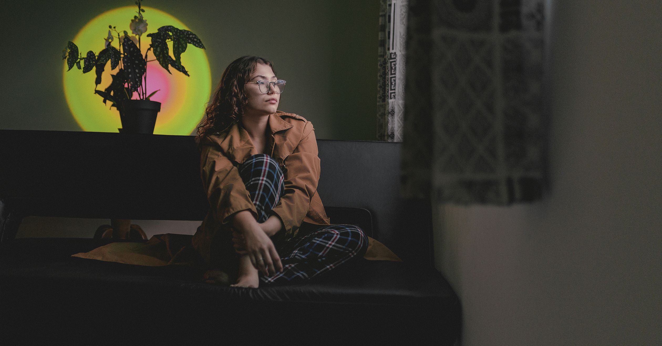 Mulher em ambiente acolhedor, luz suave, expressão de alívio em momento de pausa