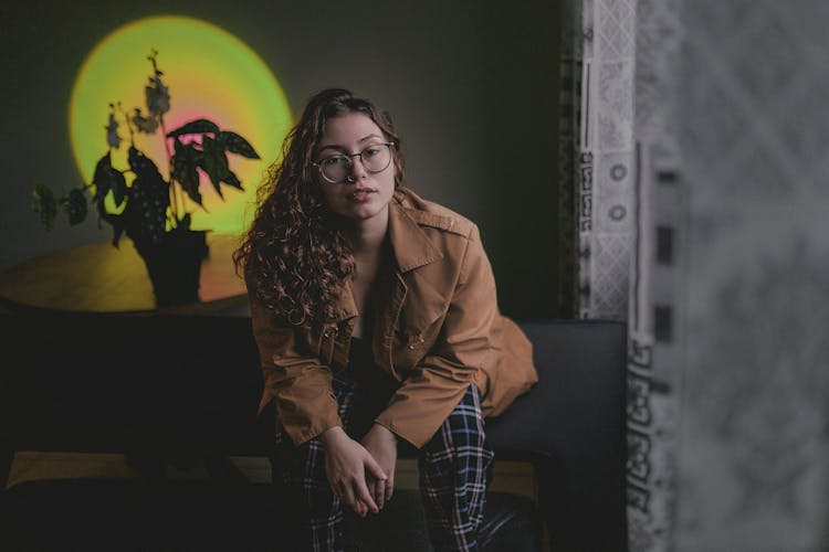 Girl In Glasses Sitting On Bench At Home