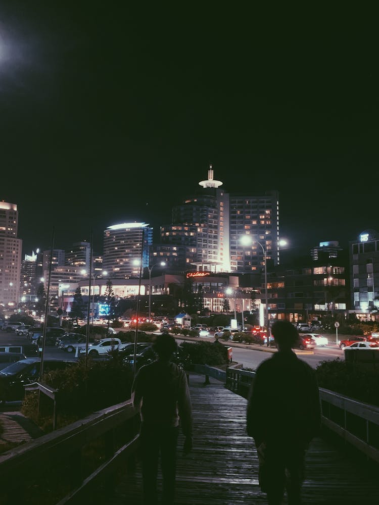 People Walking In Illuminated City At Night