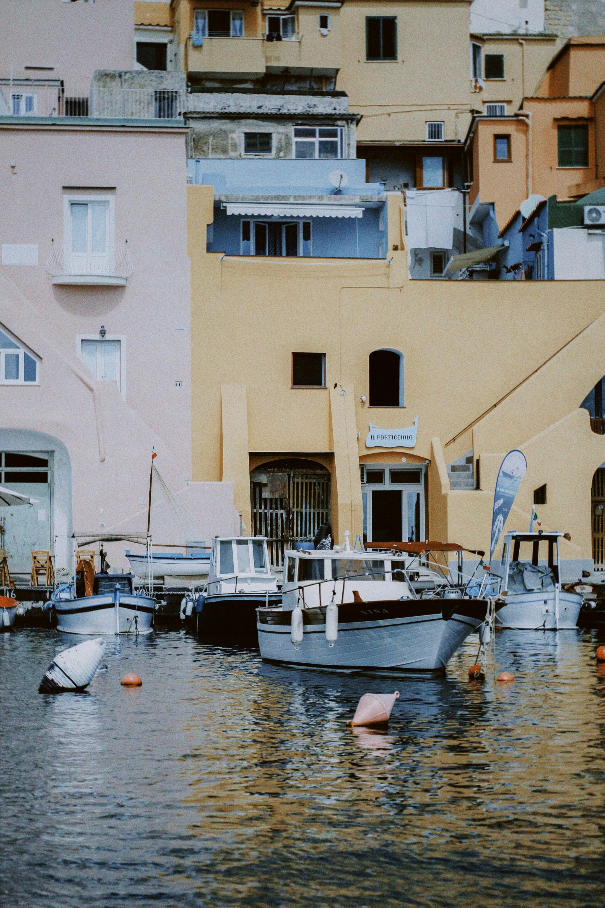 Vibrant boats docked by colorful buildings in a scenic harbor.