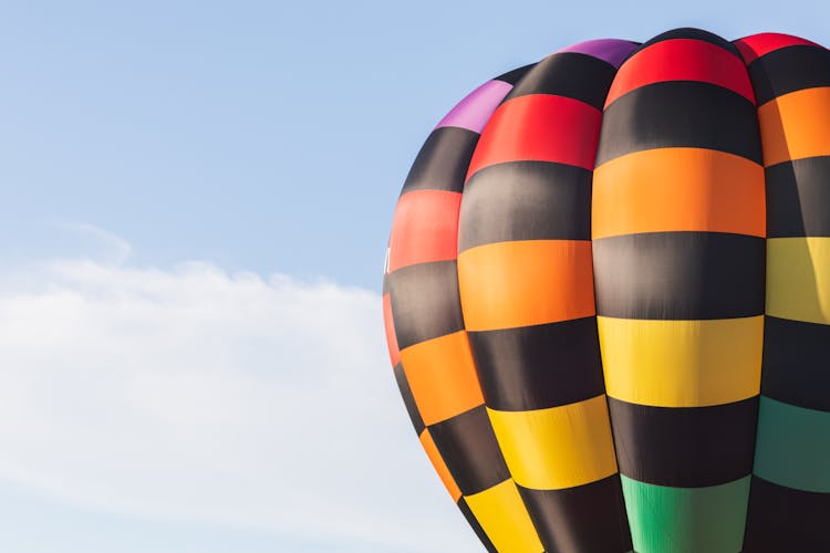 View Of A Hot Air Balloon Flying Against Blue Sky 