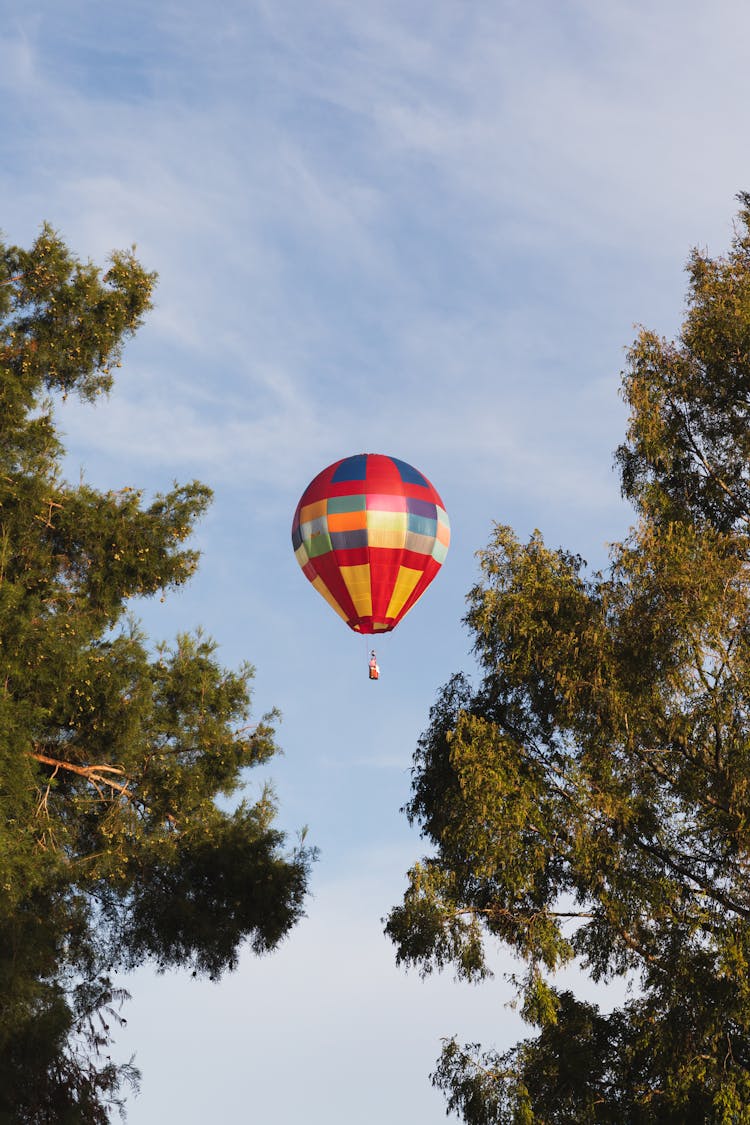 View Of A Hot Air Balloon Flying Against Blue Sky 